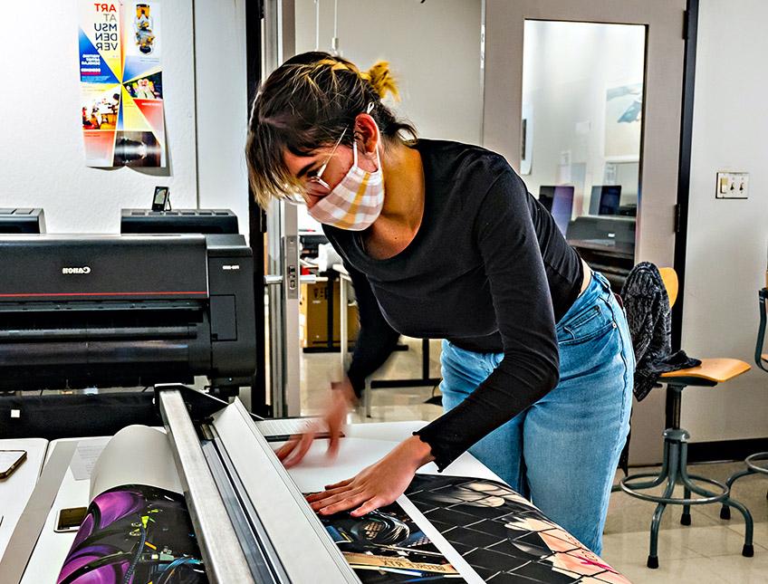 Woman cutting a large sheet of paper